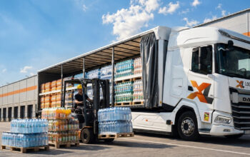 Ciężarówka XL LOGISTICS załadowana paletami wody i soków, gotowa do transportu napojów